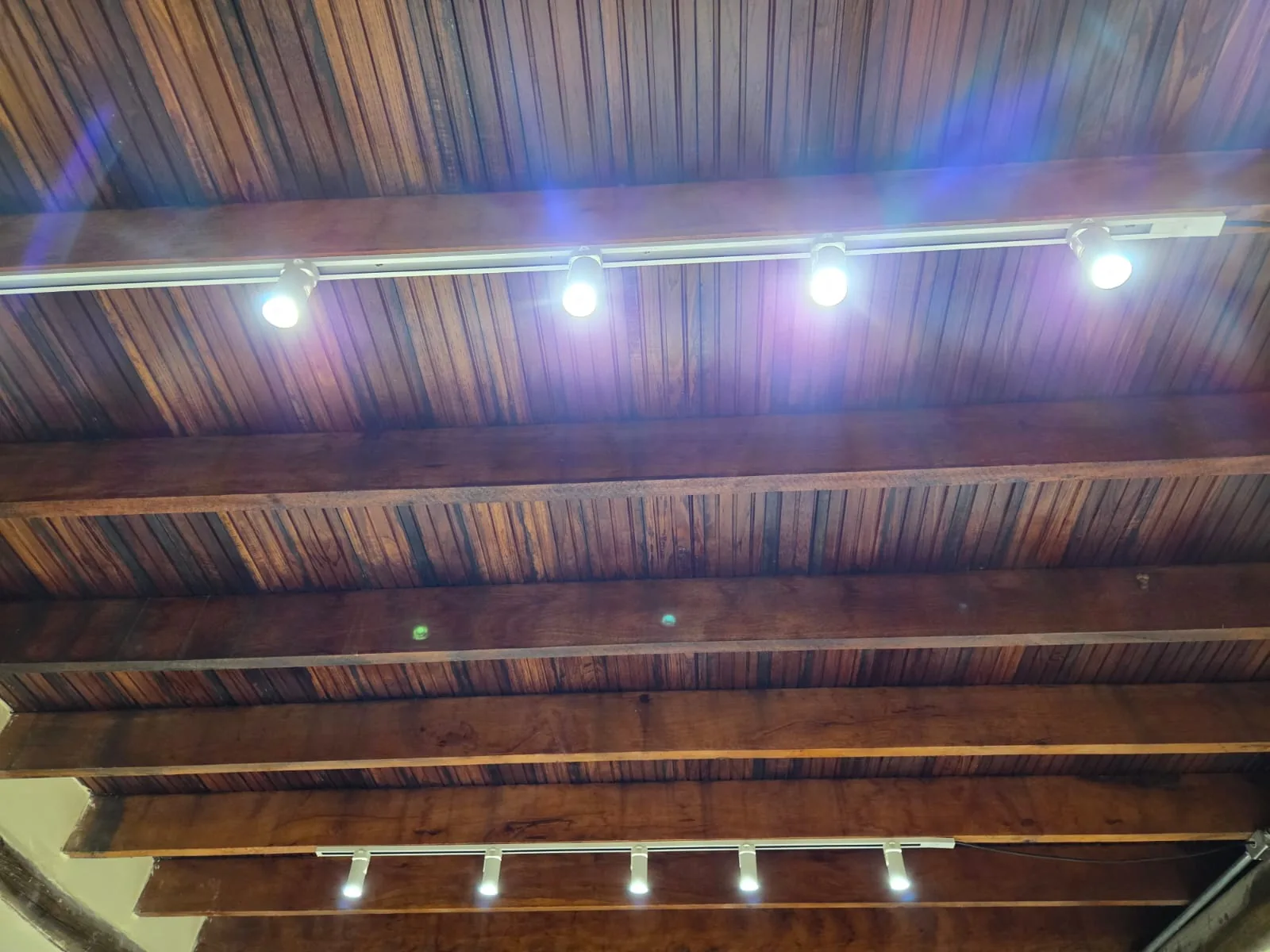 Trilho de iluminação instalado em forro de madeira